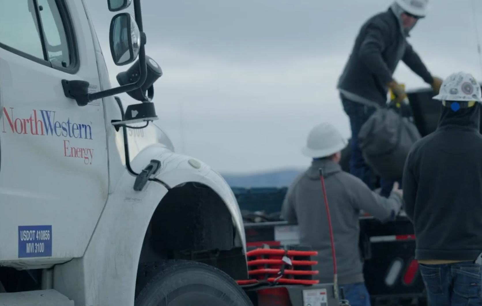 Three crew members unloading truck at worksite